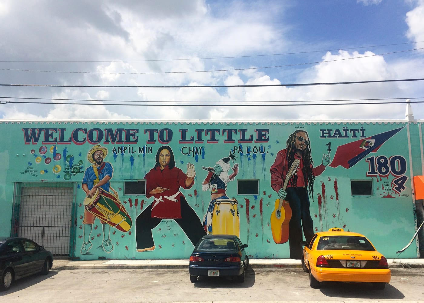 Welcome to Little Haiti mural with musicians, dancers, and the Haitian flag